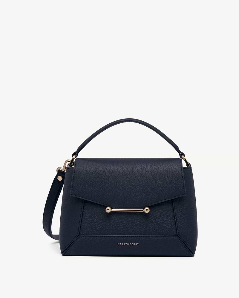 Navy Strathberry mosaic bag with top handle and gold bar detail.