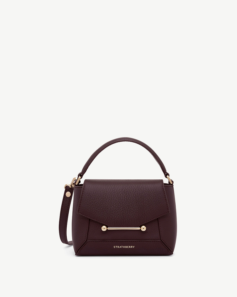 Strathberry burgundy Mosaic Nano bag with top handle, strap and gold bar.