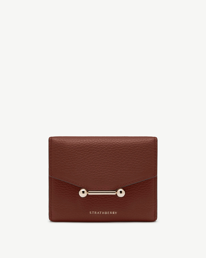 Walnut leather trifold wallet with gold bar hardware and Strathberry logo.