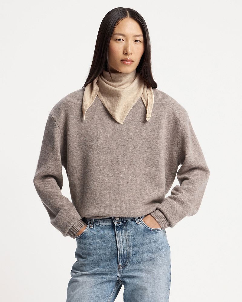 Model wearing an oat-coloured cashmere bandana tied around her neck.