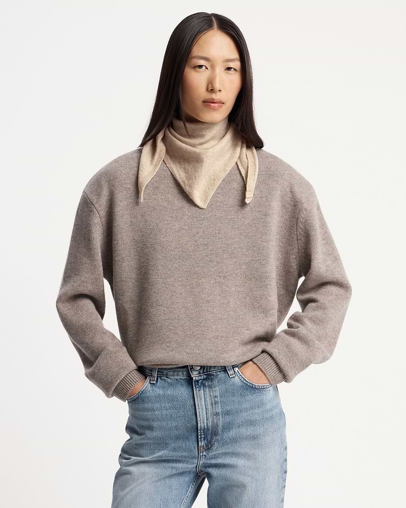 Model wearing an oat-coloured cashmere bandana tied around her neck.