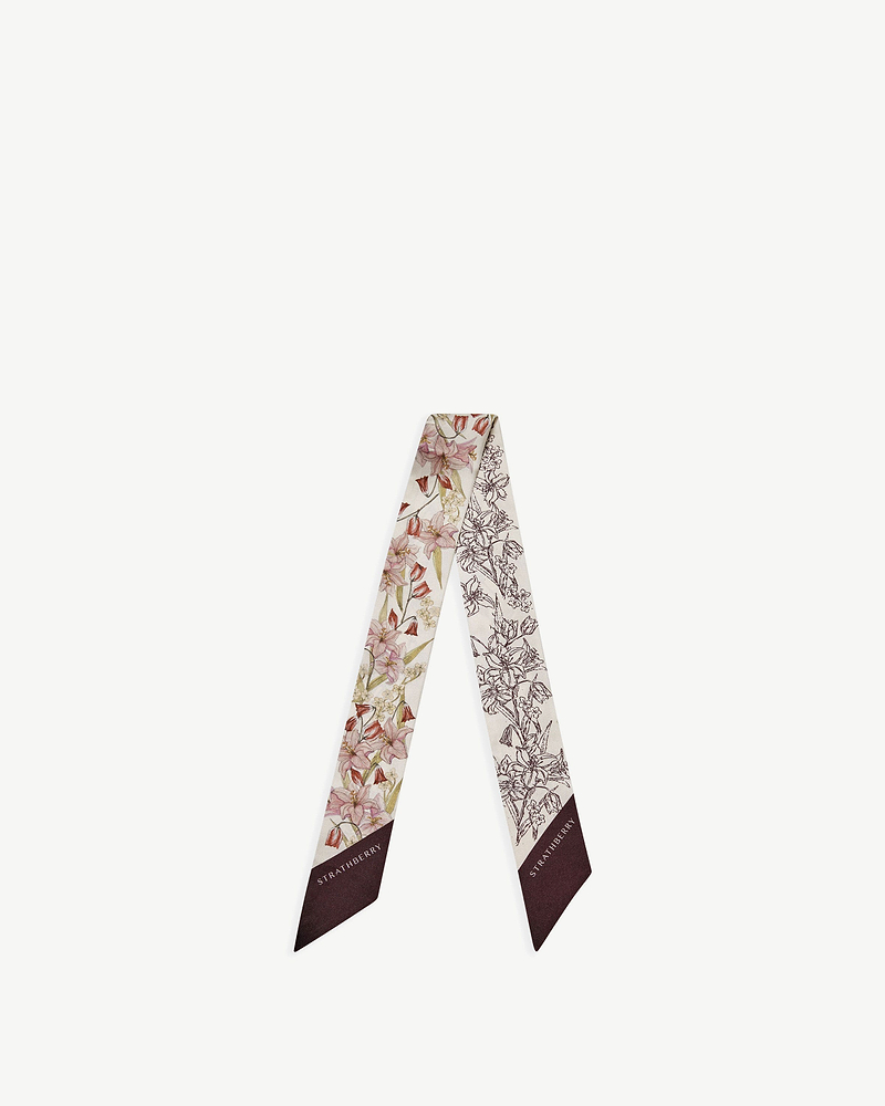 Silk skinny scarf with burgundy outline floral print and Strathberry logo on end.