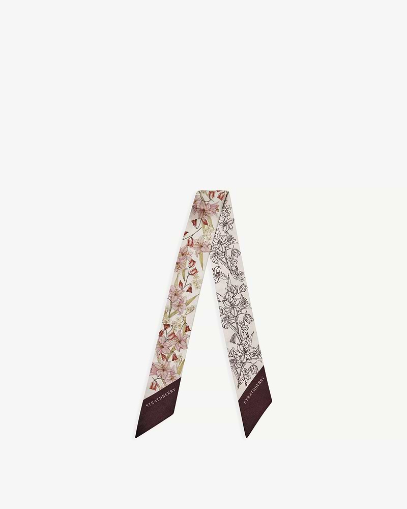 Silk skinny scarf with burgundy outline floral print and Strathberry logo on end.