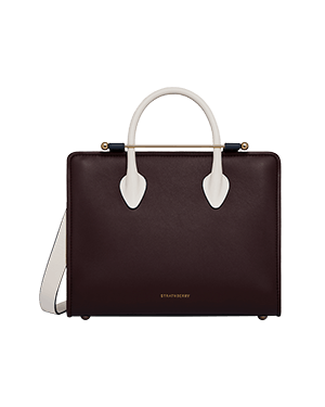 Burgundy midi tote with navy strap and vanilla handles, Strathberry logo visible.