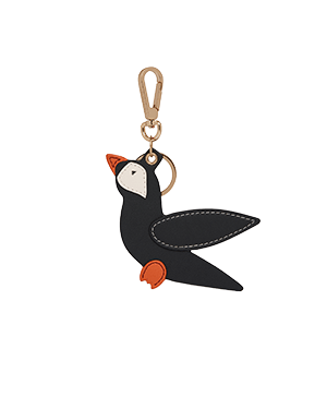 Black puffin-shaped bag charm with vanilla face, marmalade beak and feet, gold clip