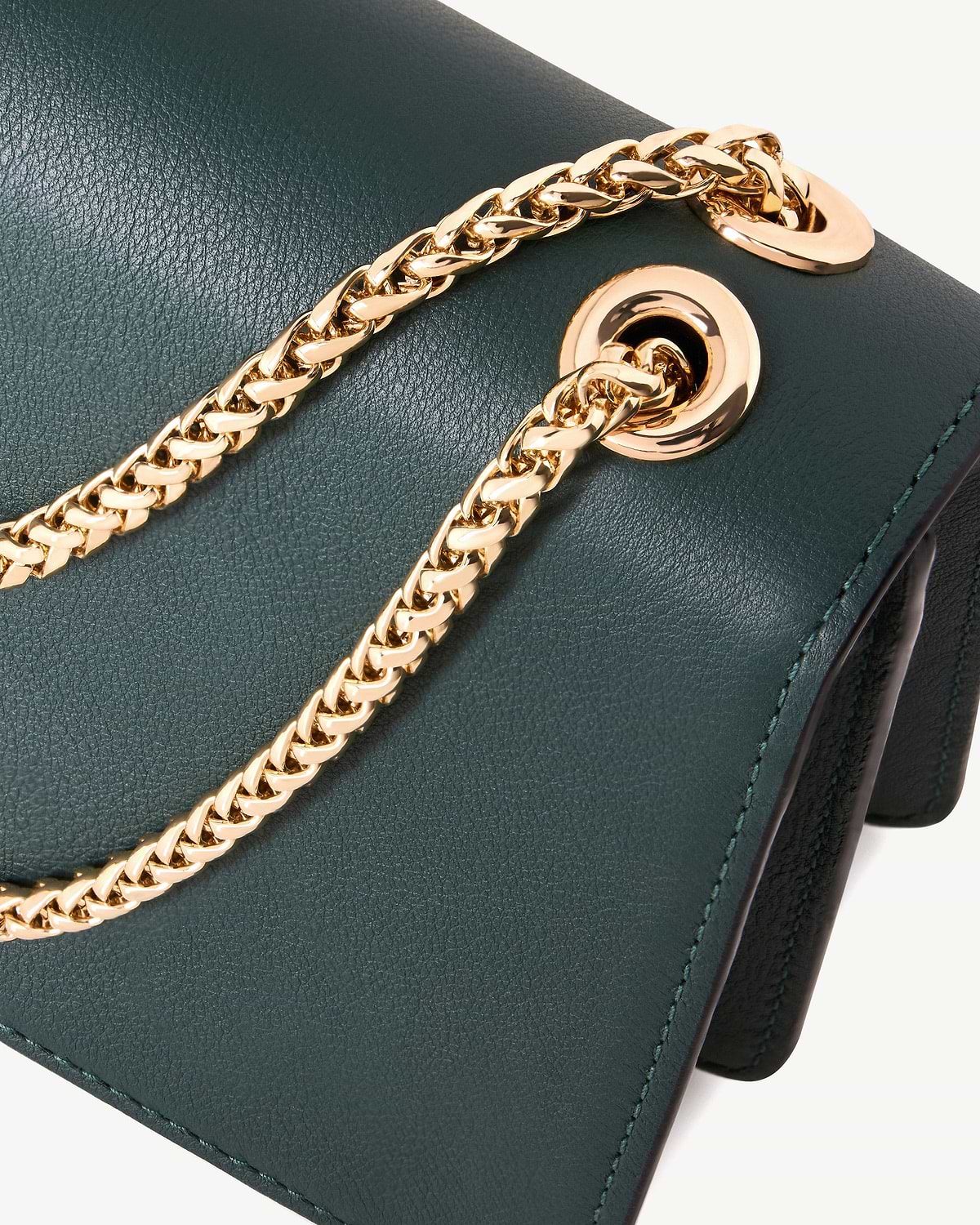 Bottle green East/West Mini leather bag showing gold chain threaded through eyelet.