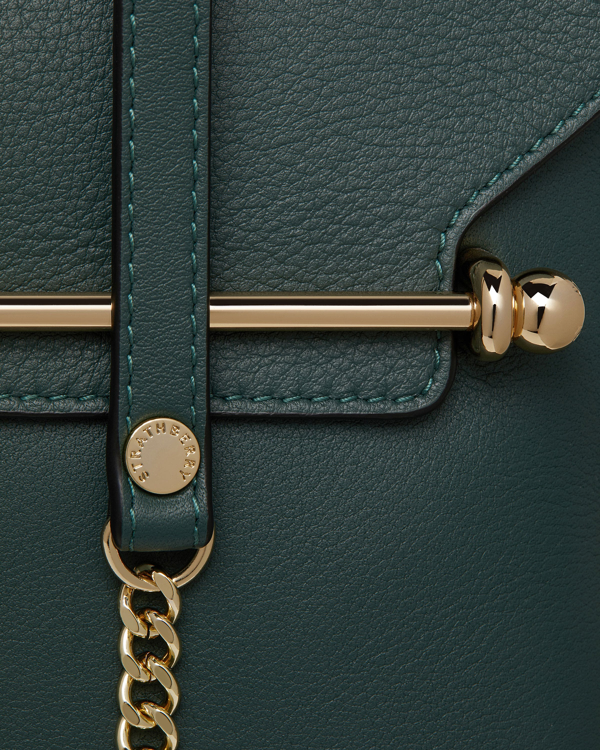 Strathberry Stylist bottle green leather bag detail showing gold hardware and chain