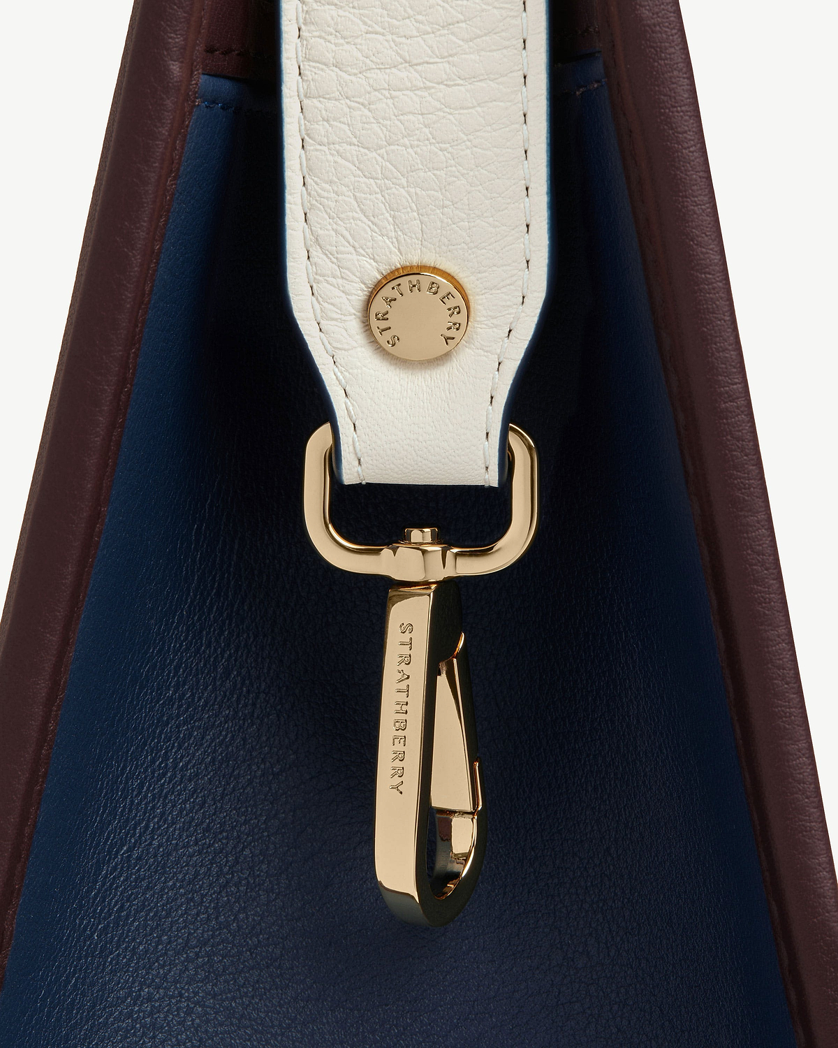 Burgundy and navy midi tote side with vanilla strap and gold Strathberry hardware