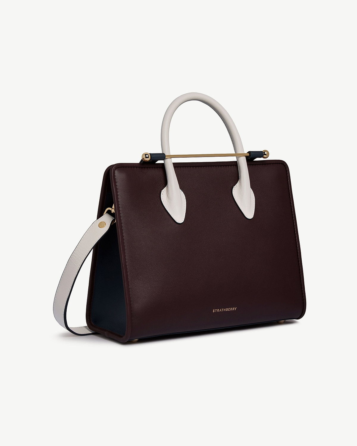 Burgundy midi tote with vanilla handles, navy sides, gold bar detail, Strathberry.