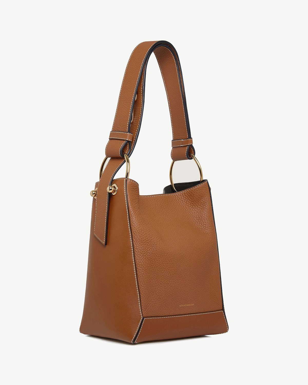 Tan leather midi bucket bag with vanilla stitching and gold ring handles.