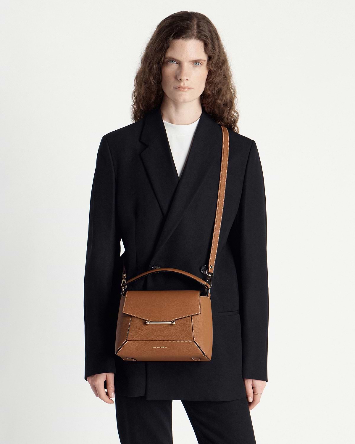 Model wearing Strathberry Mosaic bag in tan with vanilla stitching, front view.