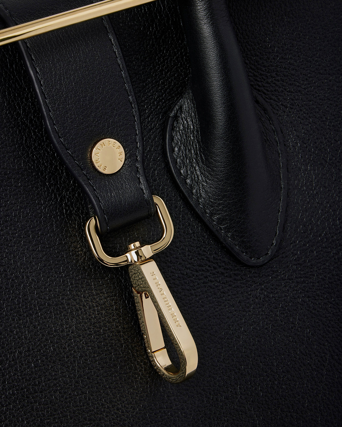 Black leather tote strap with gold clip hardware engraved Strathberry