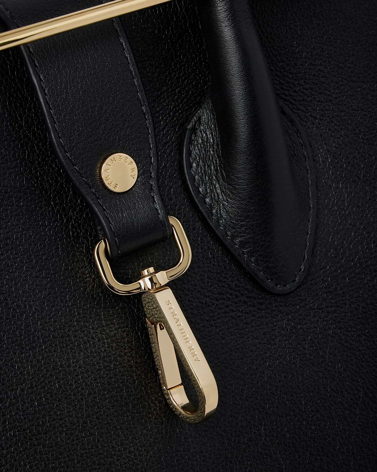 Black leather tote strap with gold clip hardware engraved Strathberry