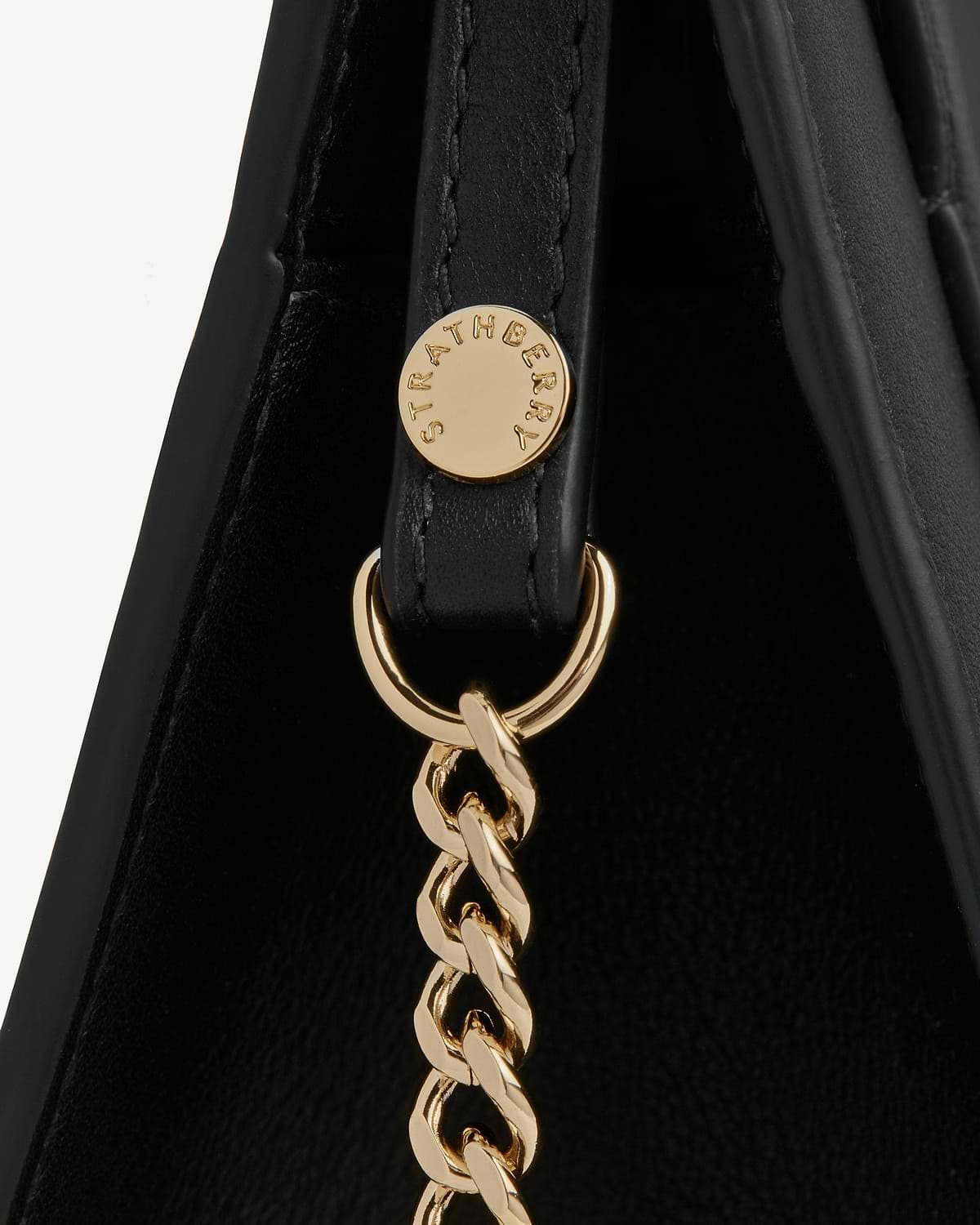 Black leather mini tote strap with gold Strathberry hardware and chain.