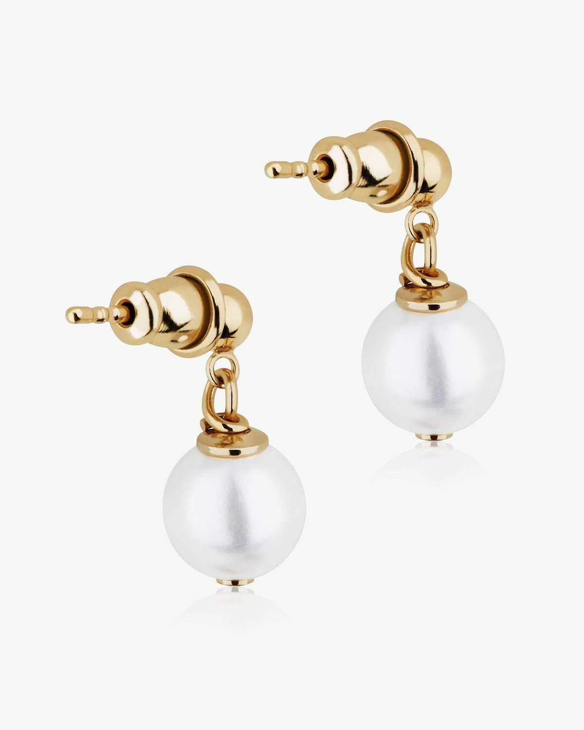 Two gold-gilded earring posts with hanging white pearl beads on white background.