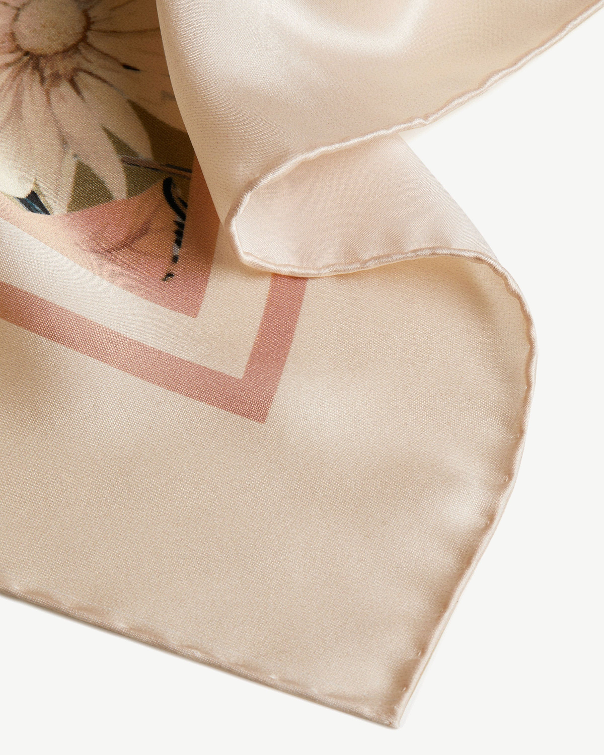 Pale peach silk square scarf with autumn floral print and folded hem detail.