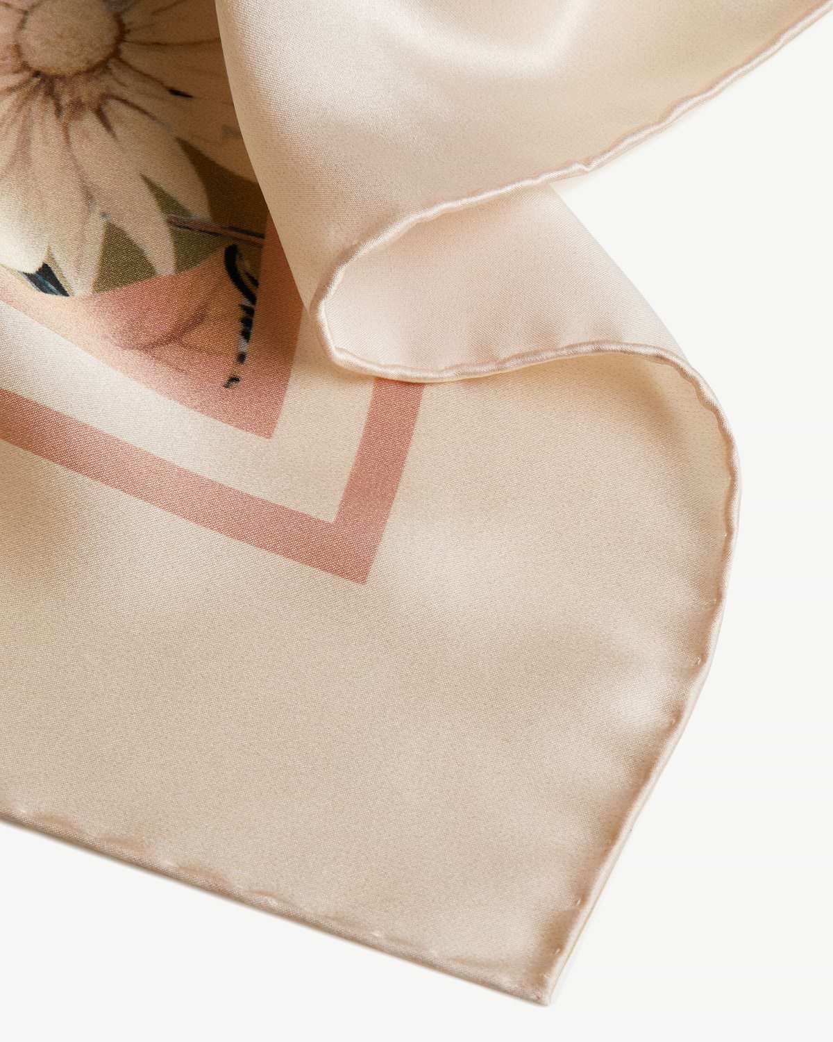 Pale peach silk square scarf with autumn floral print and folded hem detail.