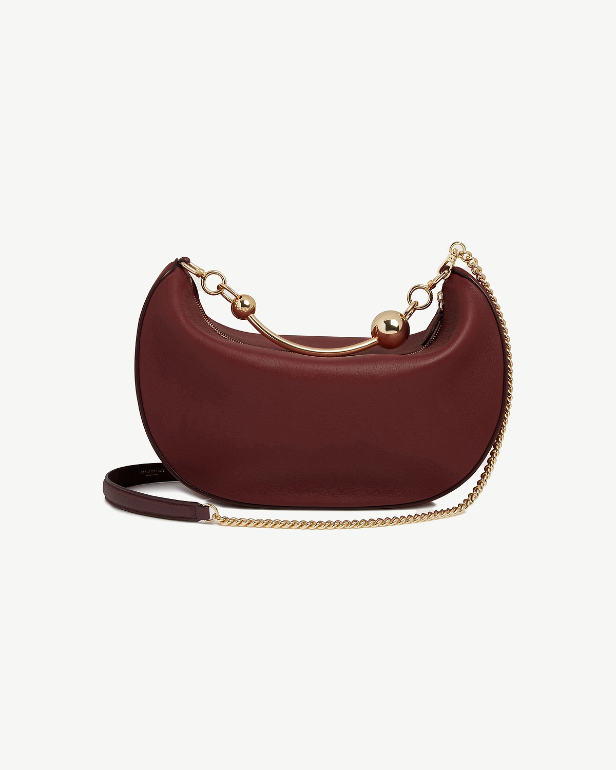 Oxblood crescent-shaped leather shoulder bag with gold chain and sphere accents.