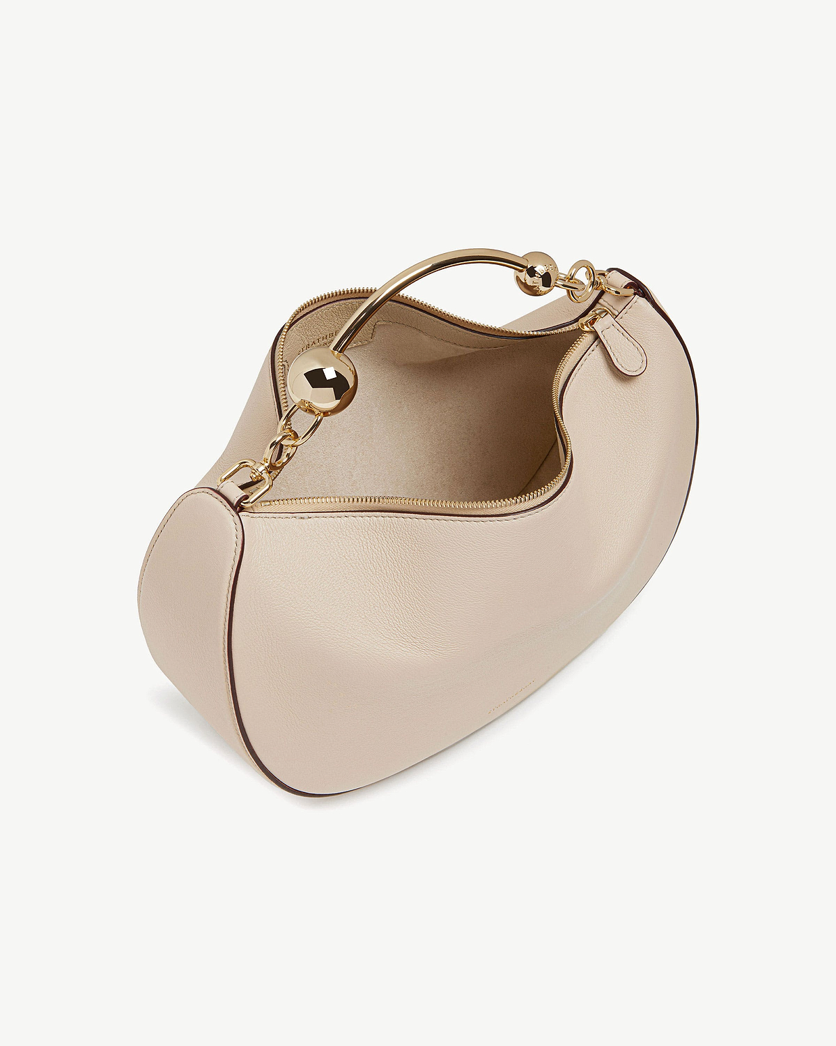 Oat crescent moon leather bag with gold curved handle and zip.