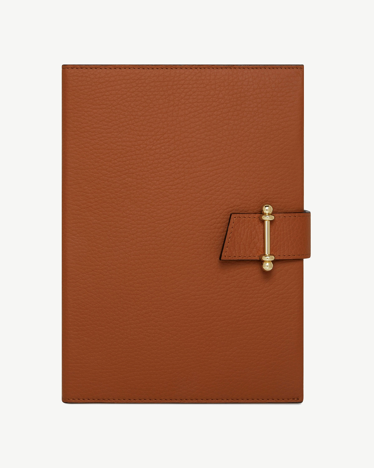 Tan leather notebook with pebbled texture and gold bar clasp.
