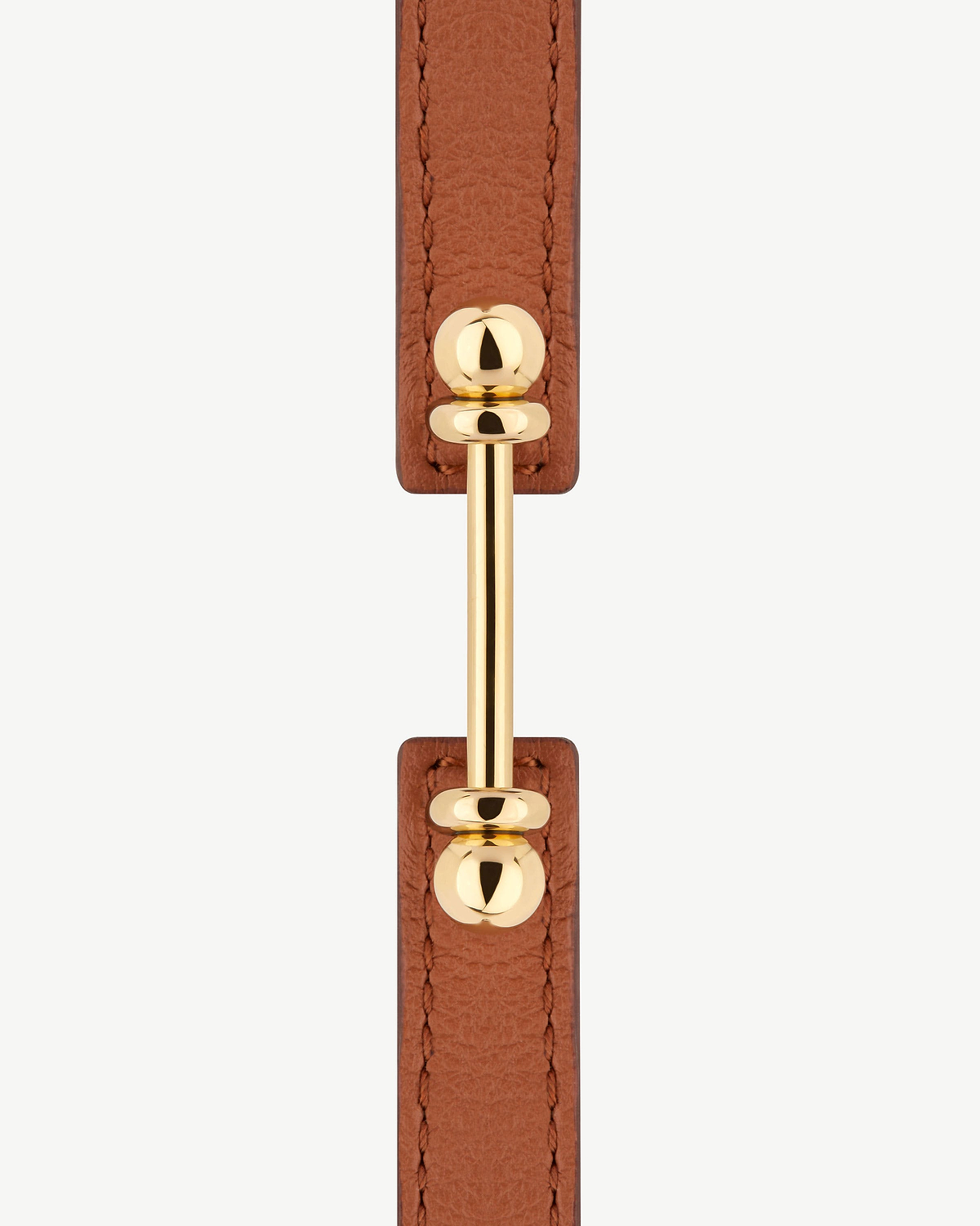 Chestnut leather bracelet with 22 carat gold music bar hardware, close-up.