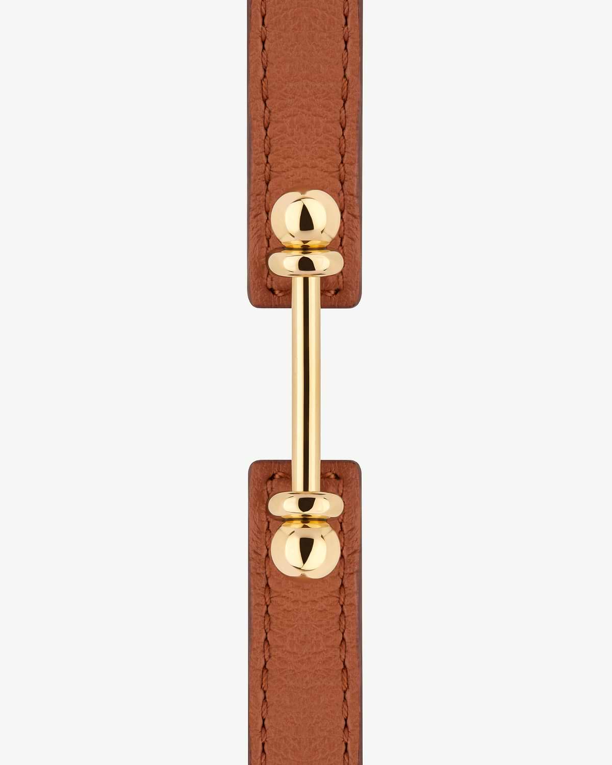 Chestnut leather bracelet with 22 carat gold music bar hardware, close-up.