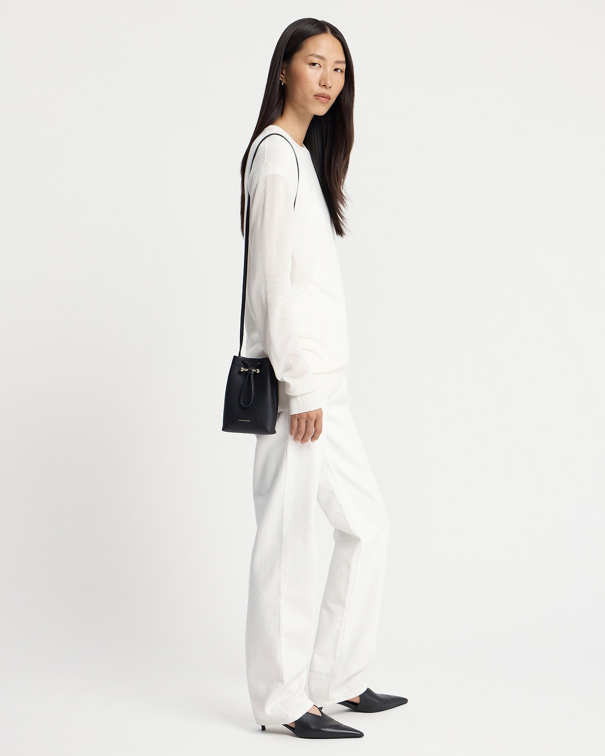 Model wearing black Strathberry Osette midi pouch with thin shoulder strap