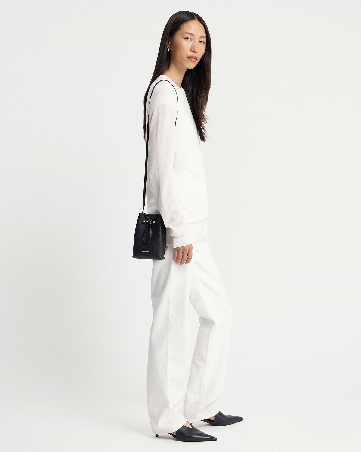 Model wearing black Strathberry Osette midi pouch with thin shoulder strap