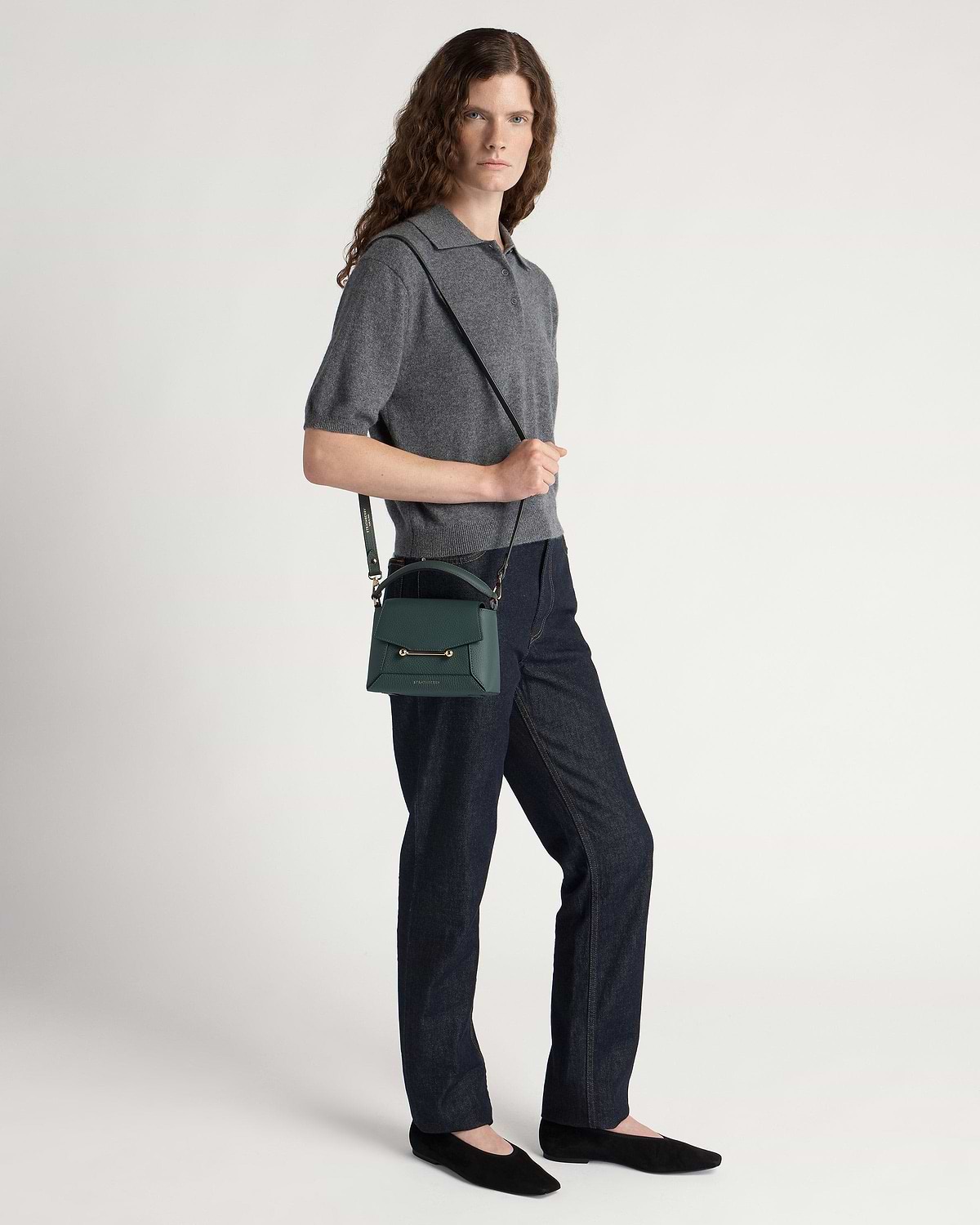 Model wearing grey top and jeans with bottle green Mosaic Nano crossbody bag.