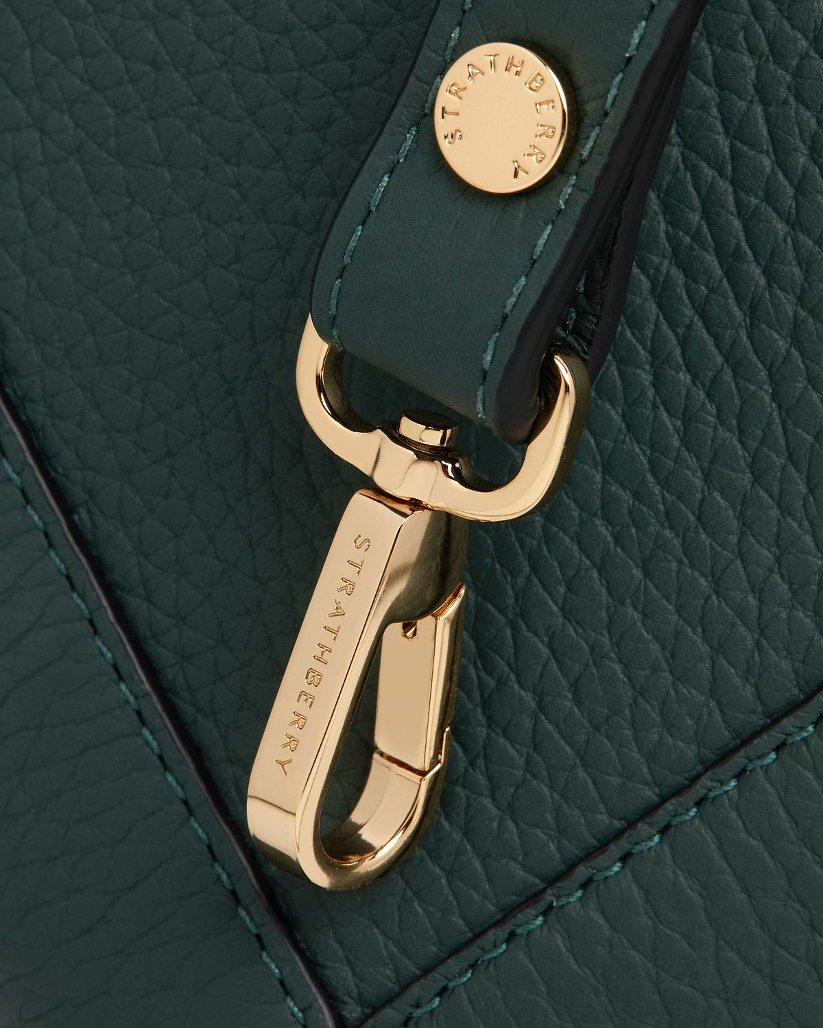 Gold Strathberry clasp on bottle green pebbled leather with contrast stitching.
