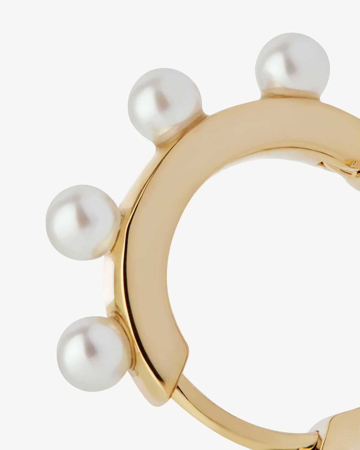 22 carat gold gilded pearl huggie with multiple round pearls along outer edge.
