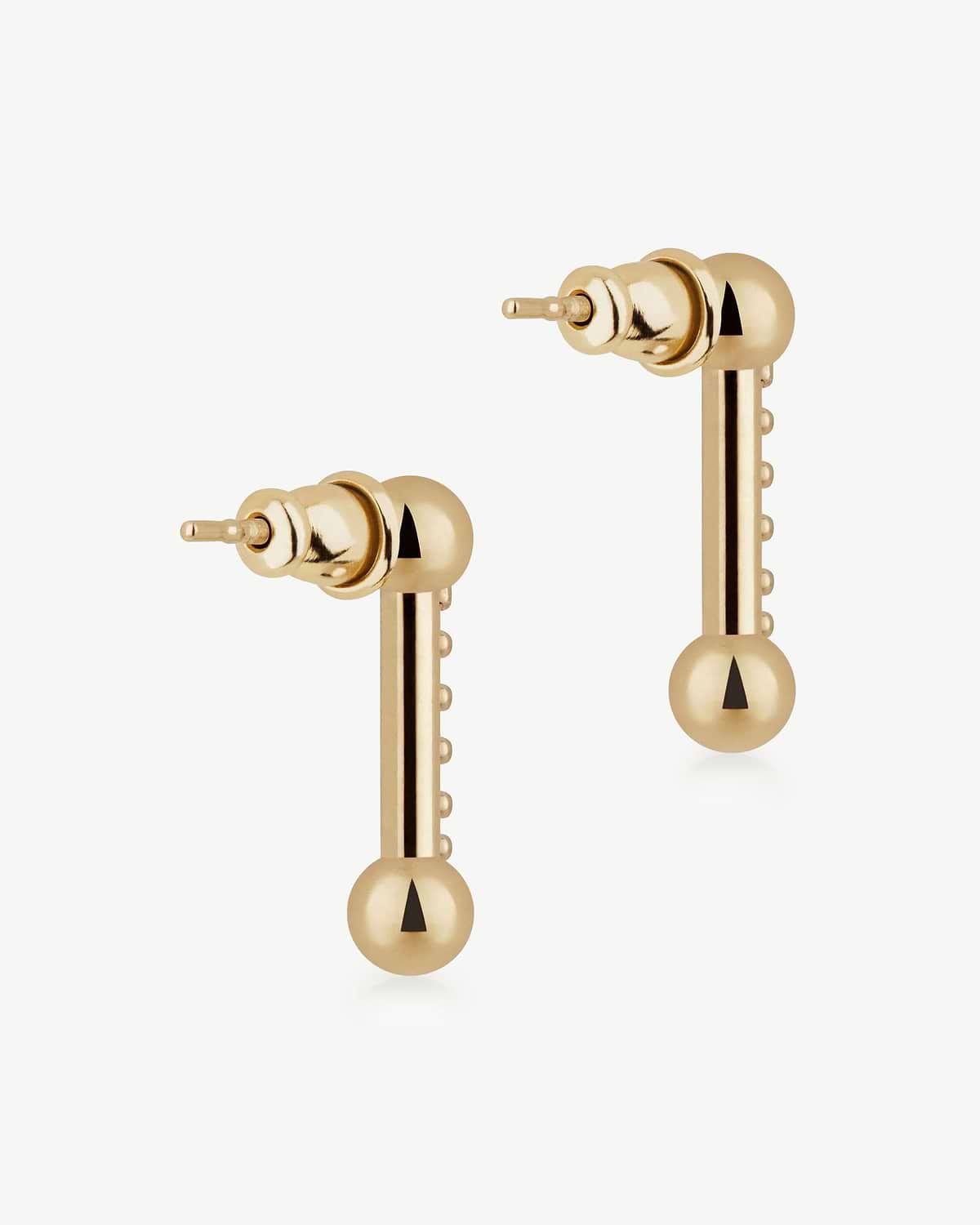 Pair of gold bar drop earrings with spherical ends on a white background.