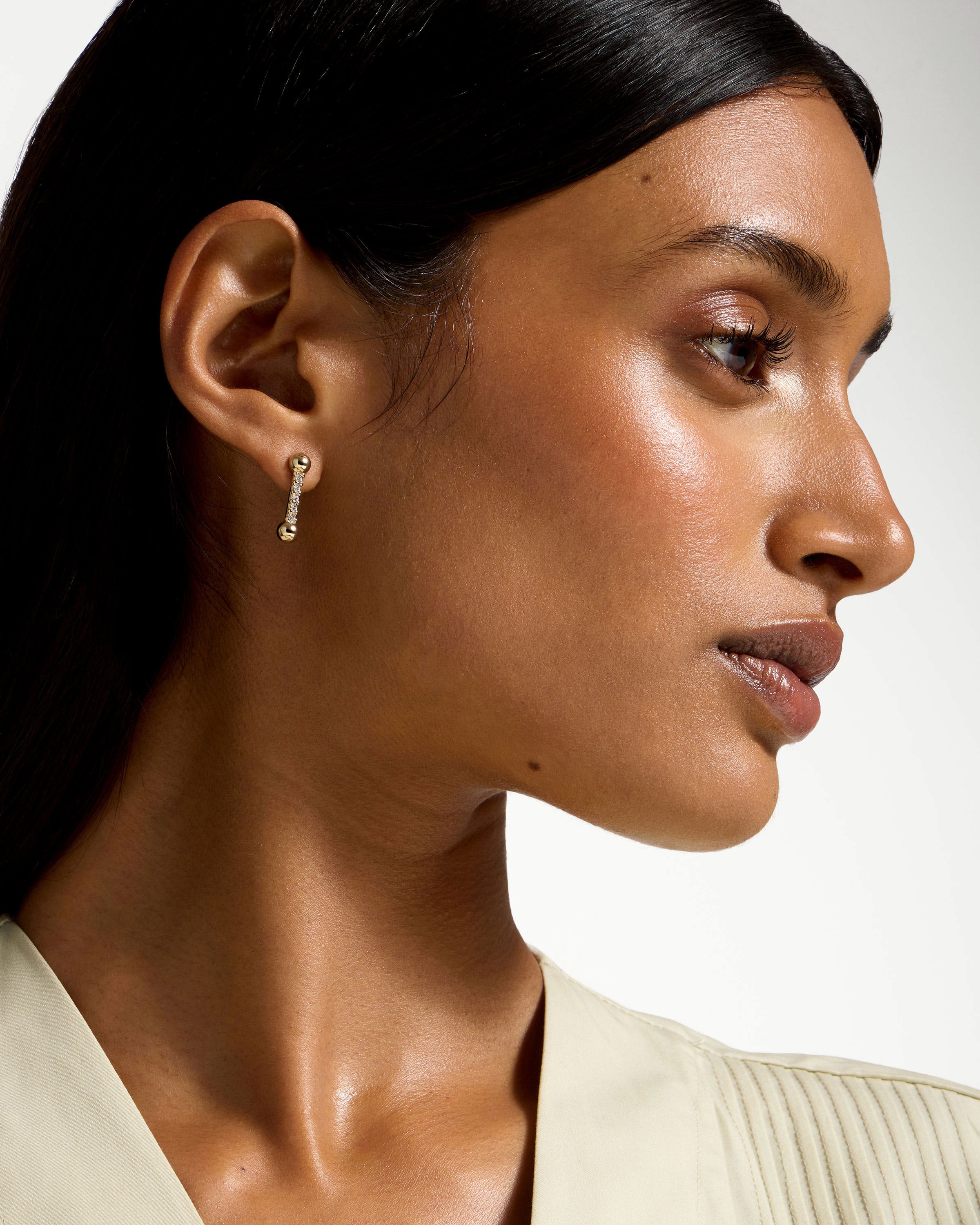 Profile of woman wearing 22-carat gold-gilded crystal mosaic drop earrings.