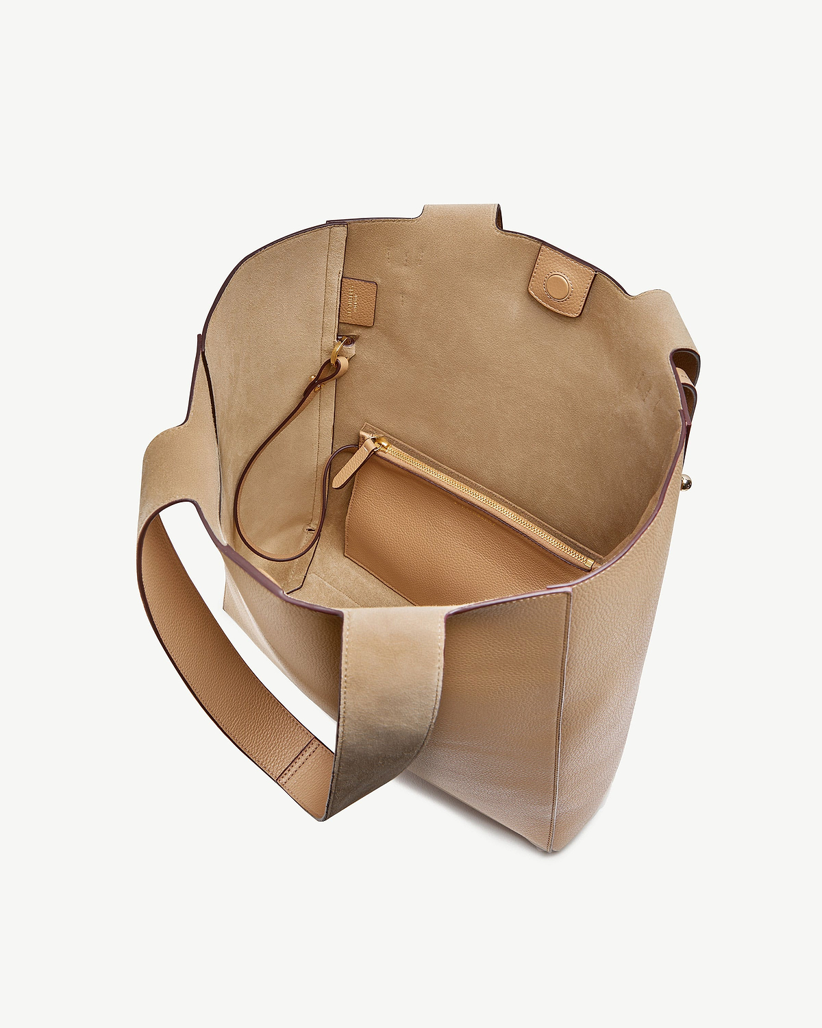 Open caramel leather tote bag showing suede interior and detachable zip pouch