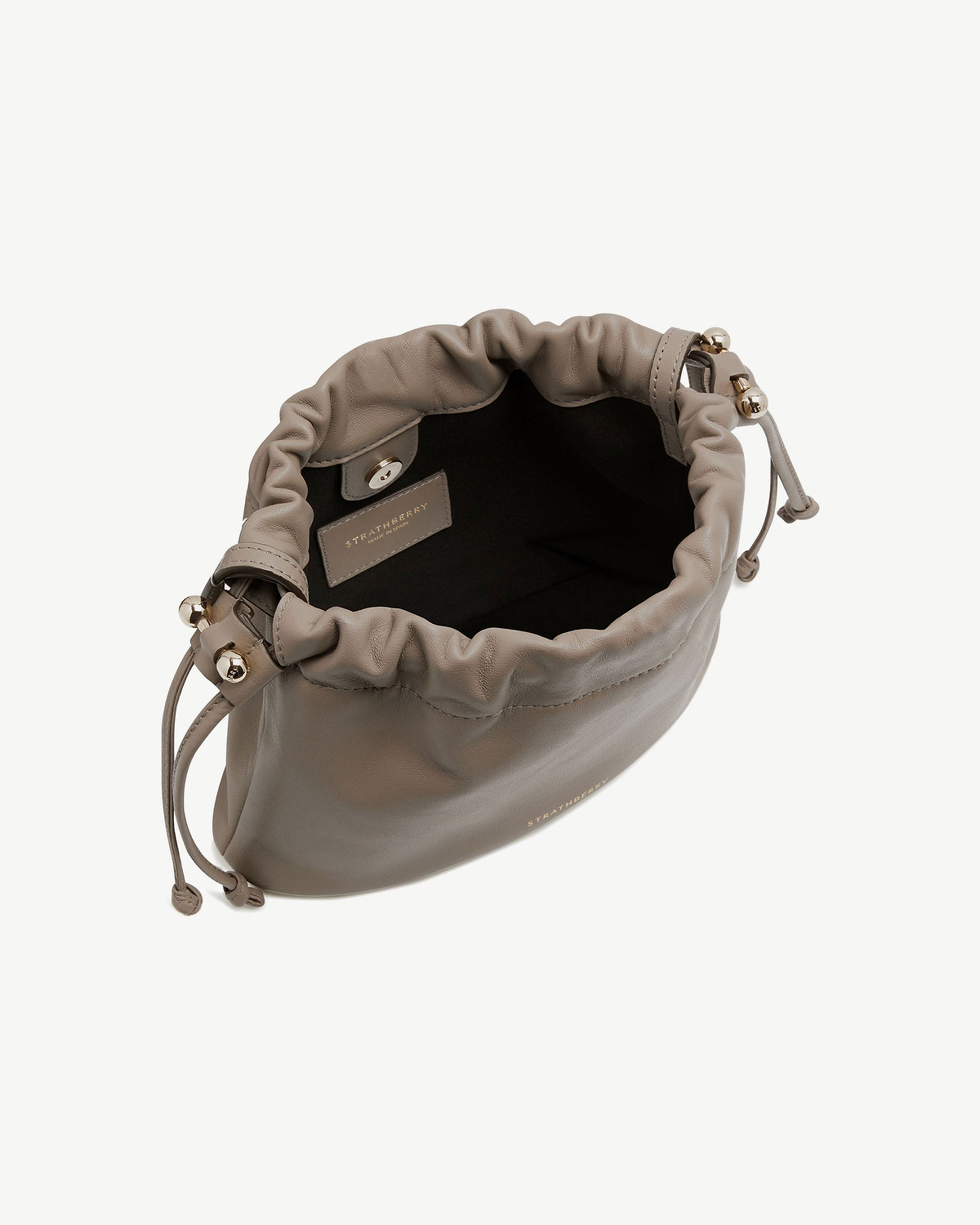 Taupe Charlotte drawstring bag with open top showing interior and Strathberry label