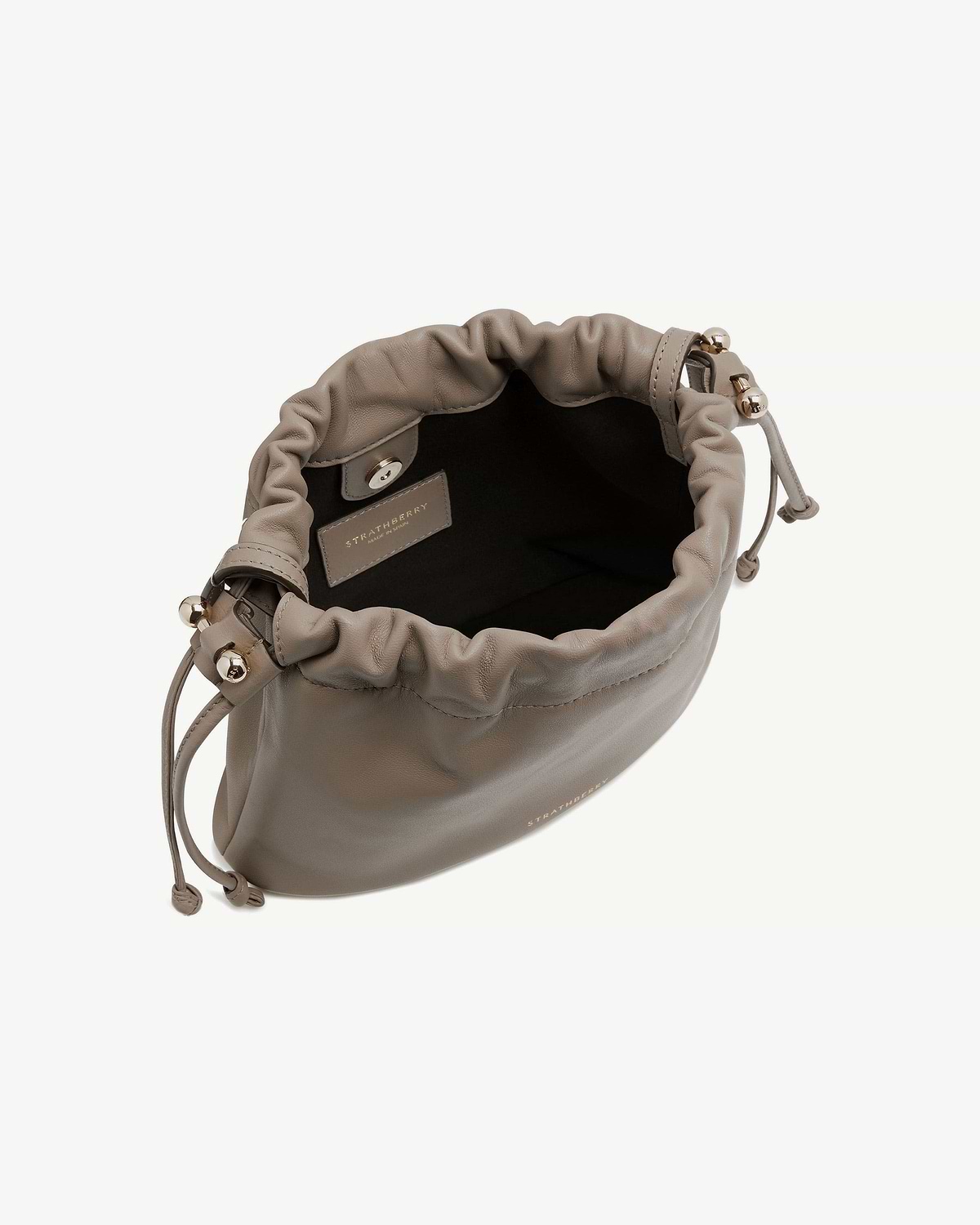 Taupe Charlotte drawstring bag with open top showing interior and Strathberry label