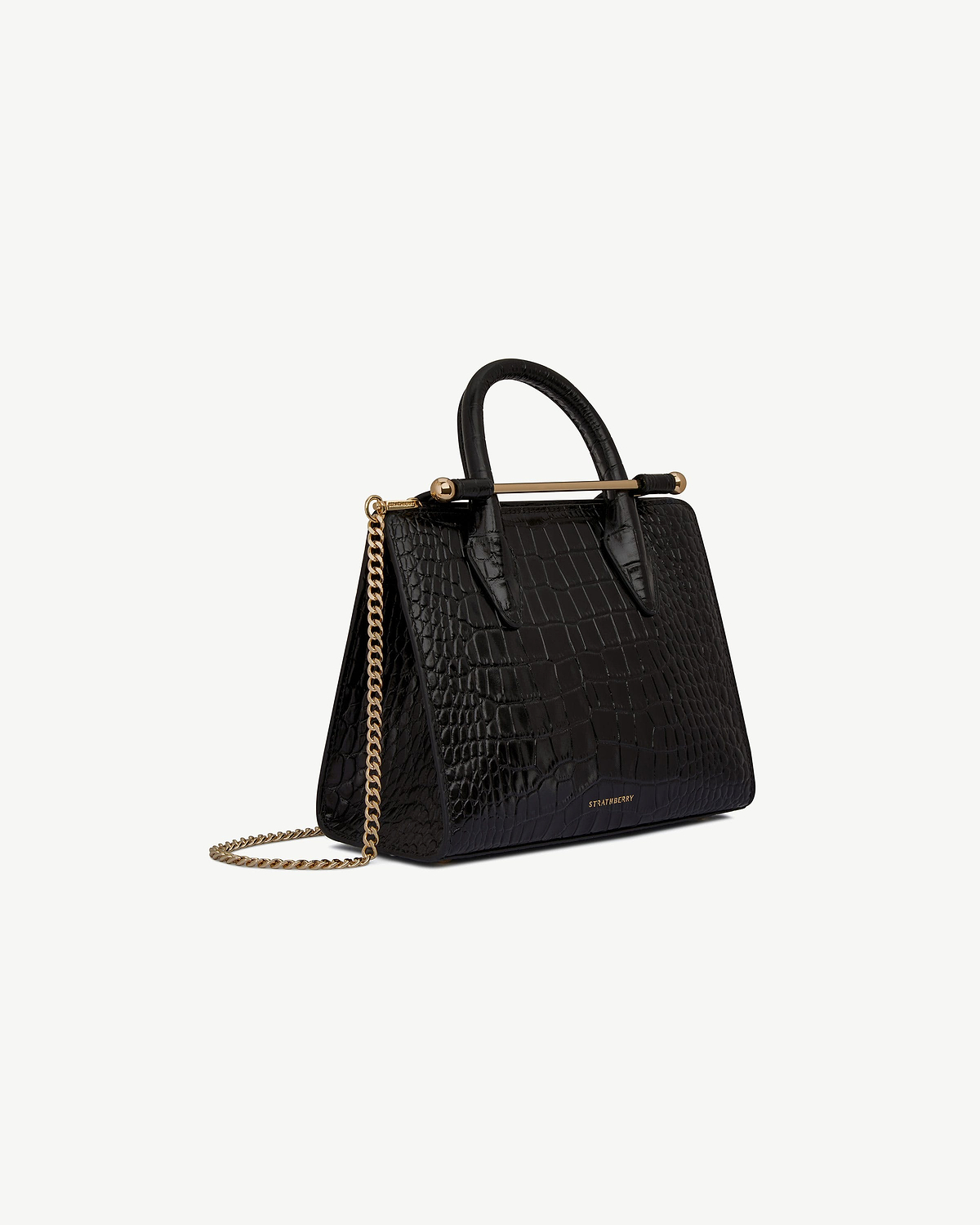 Strathberry mini tote in black croc with gold bar handle and chain strap.