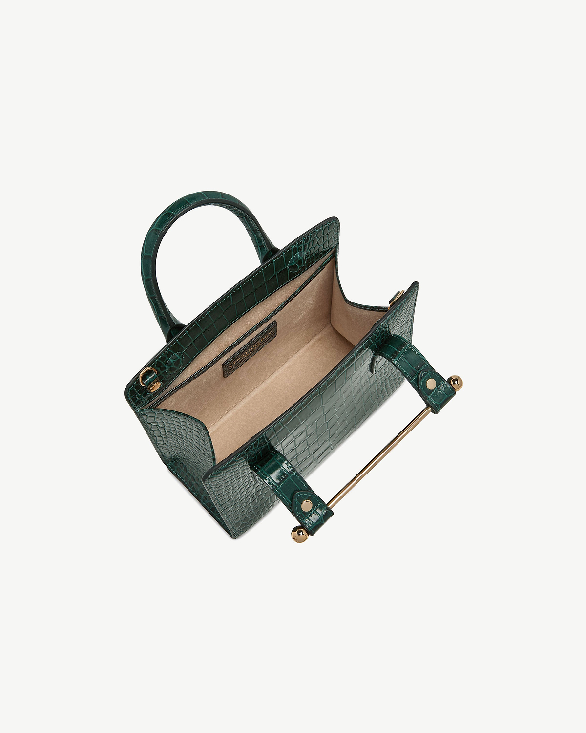 Green croc mini tote with open top, beige interior and gold metal bar.