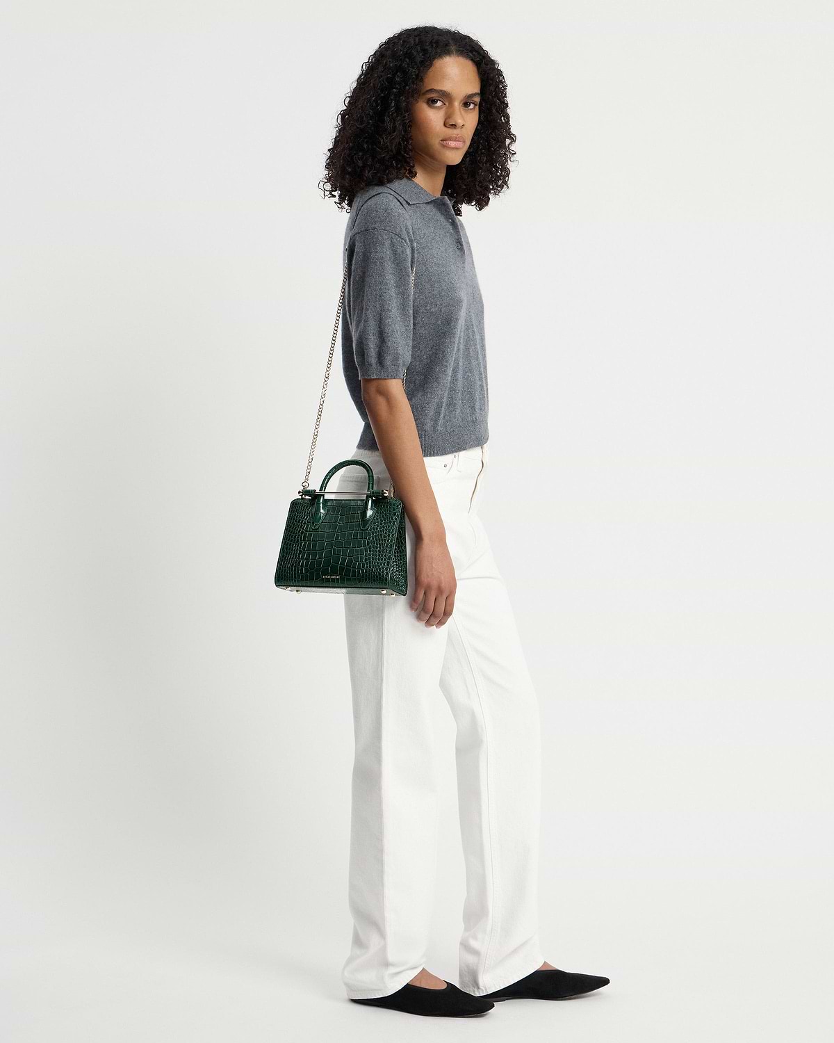 Model wearing a green croc mini tote with chain shoulder strap.