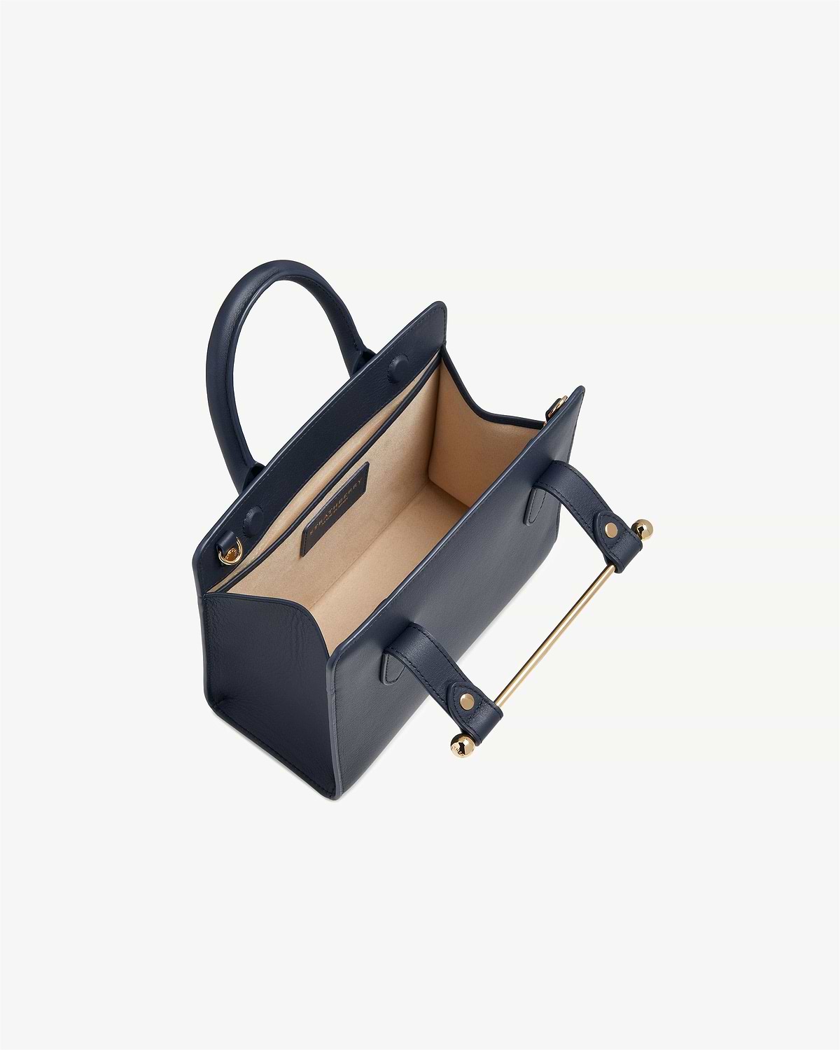 Marine blue mini tote with beige interior and gold bar handle, top view.