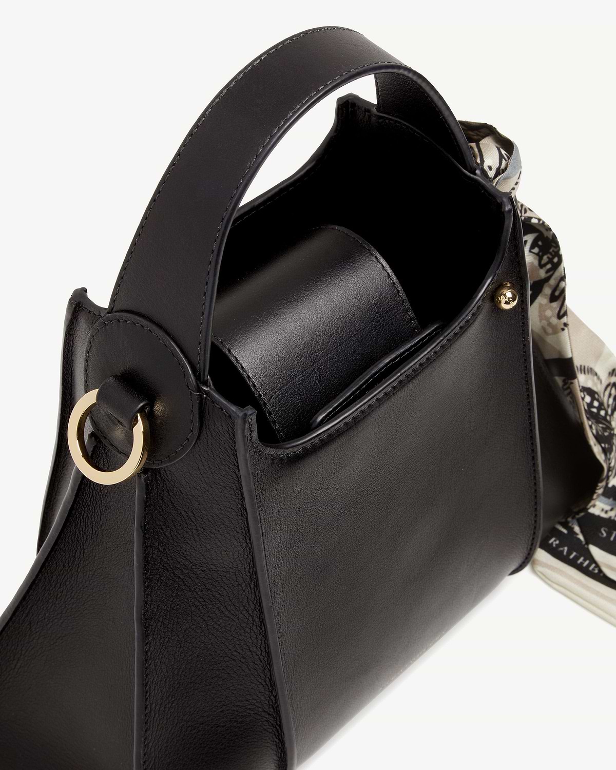 Black Arkshell leather handbag with top handle, gold ring and patterned scarf.