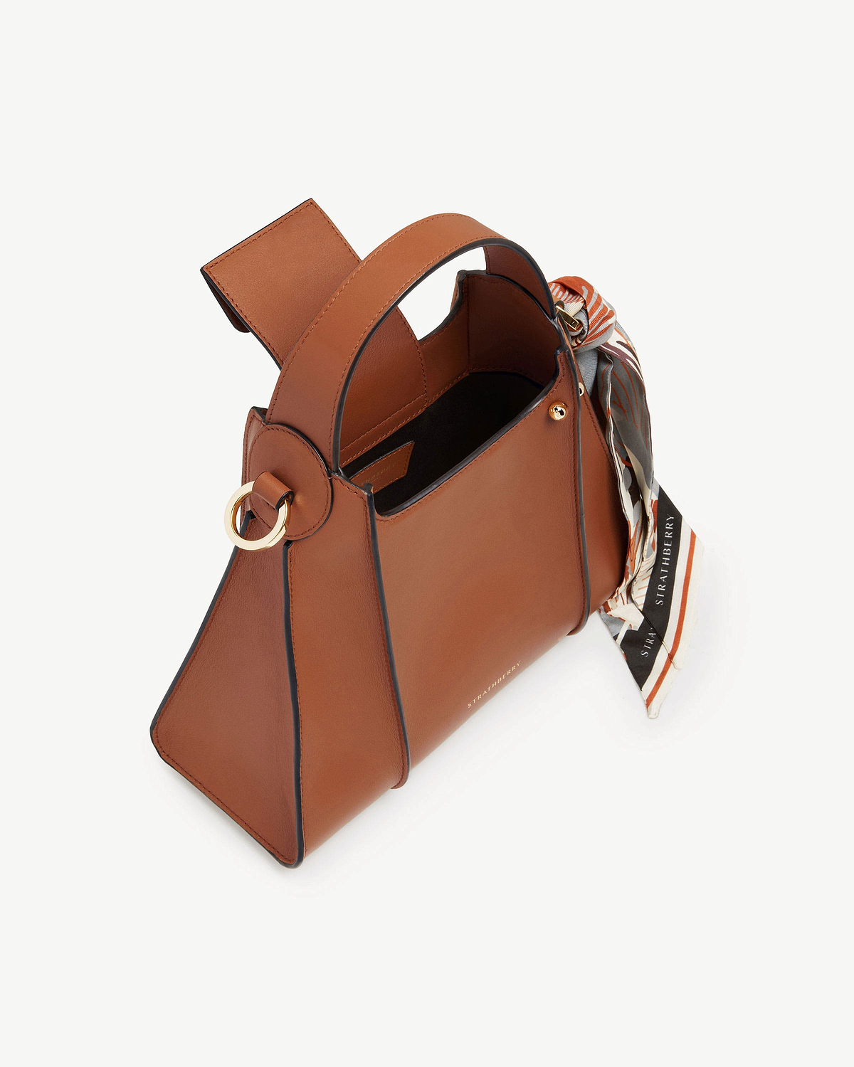 Tan Strathberry Arkshell handbag with top handle, gold ring detail and patterned scarf.
