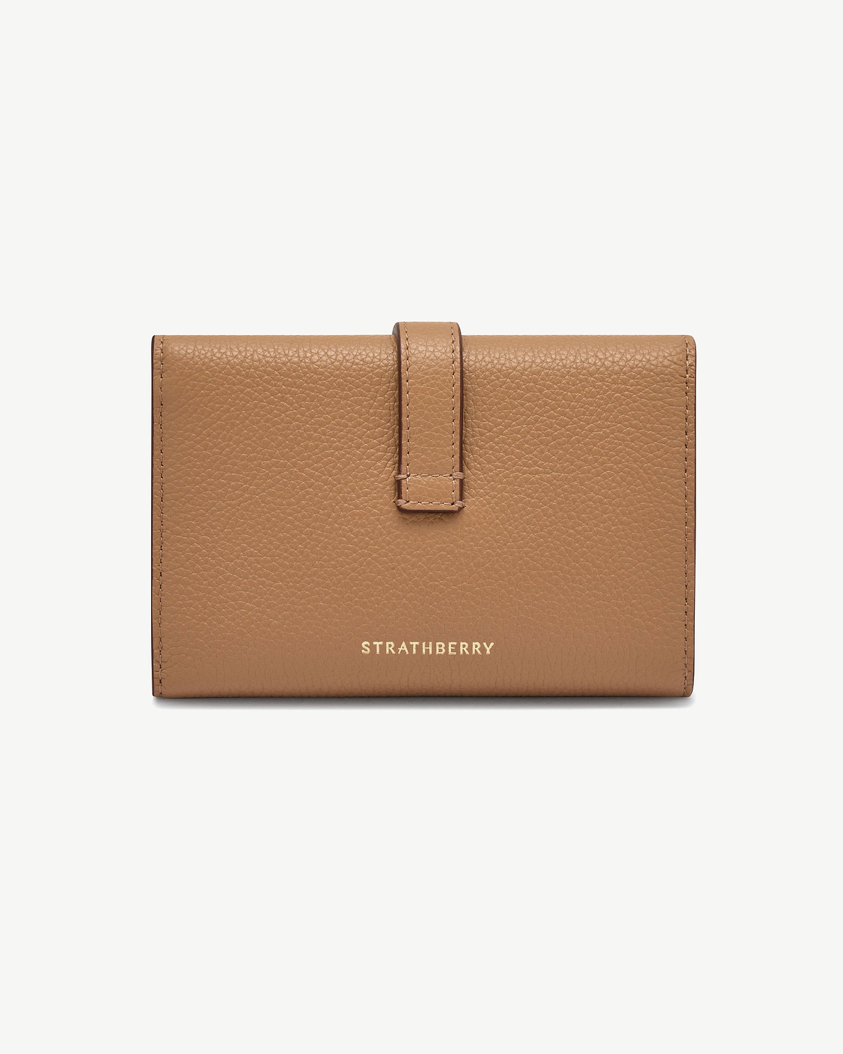 Caramel pebbled leather Kite medium trifold wallet with gold Strathberry logo and strap.