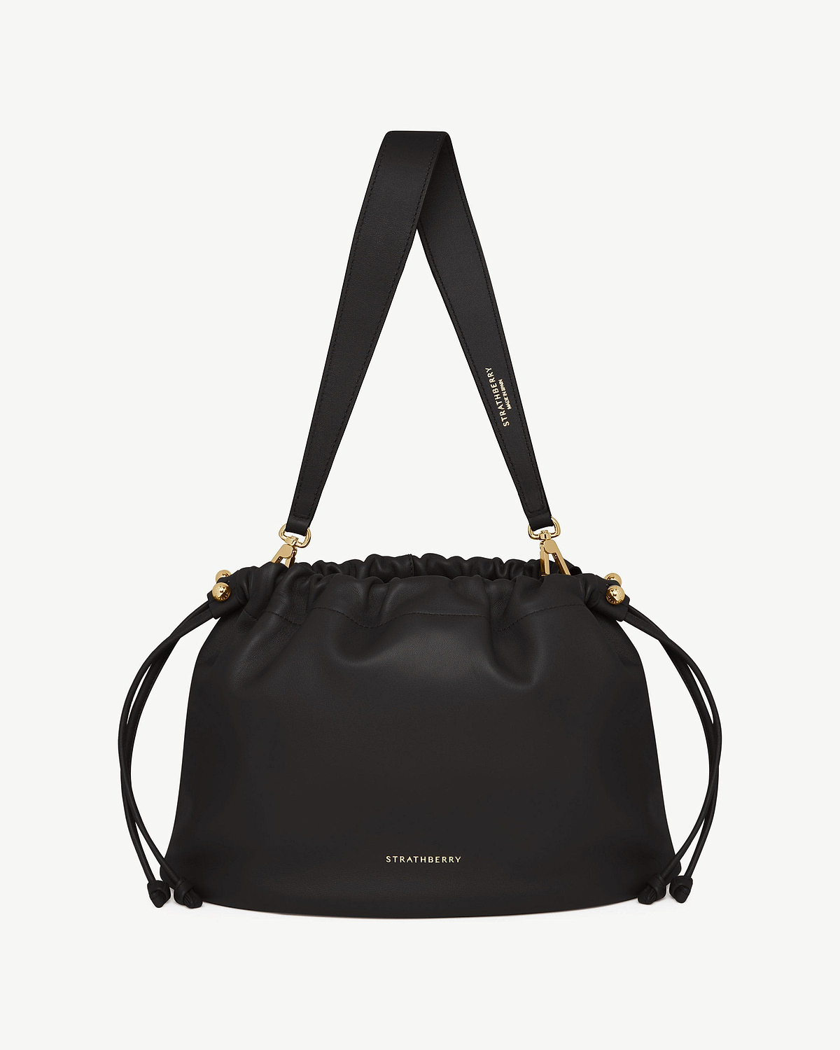 Black Charlotte Midi drawstring bag with wide shoulder strap and gold hardware, Strathberry logo.