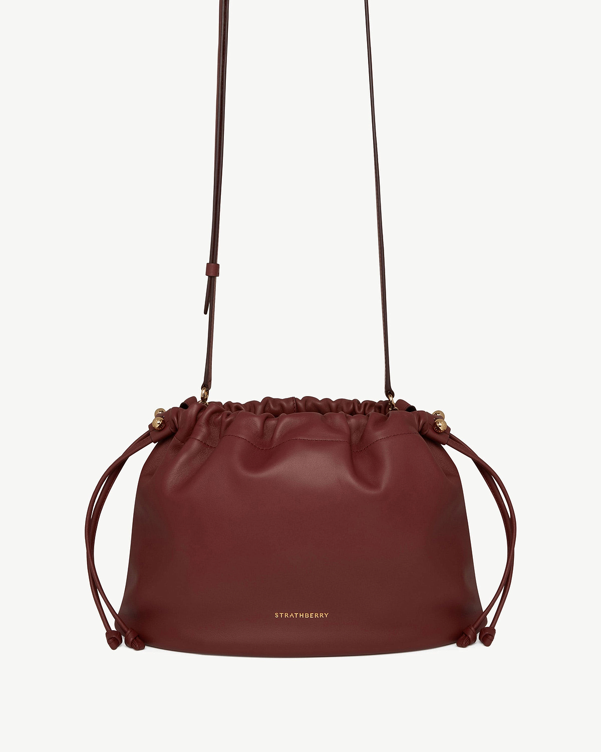 Oxblood leather drawstring bag with adjustable shoulder strap, Strathberry logo centre front