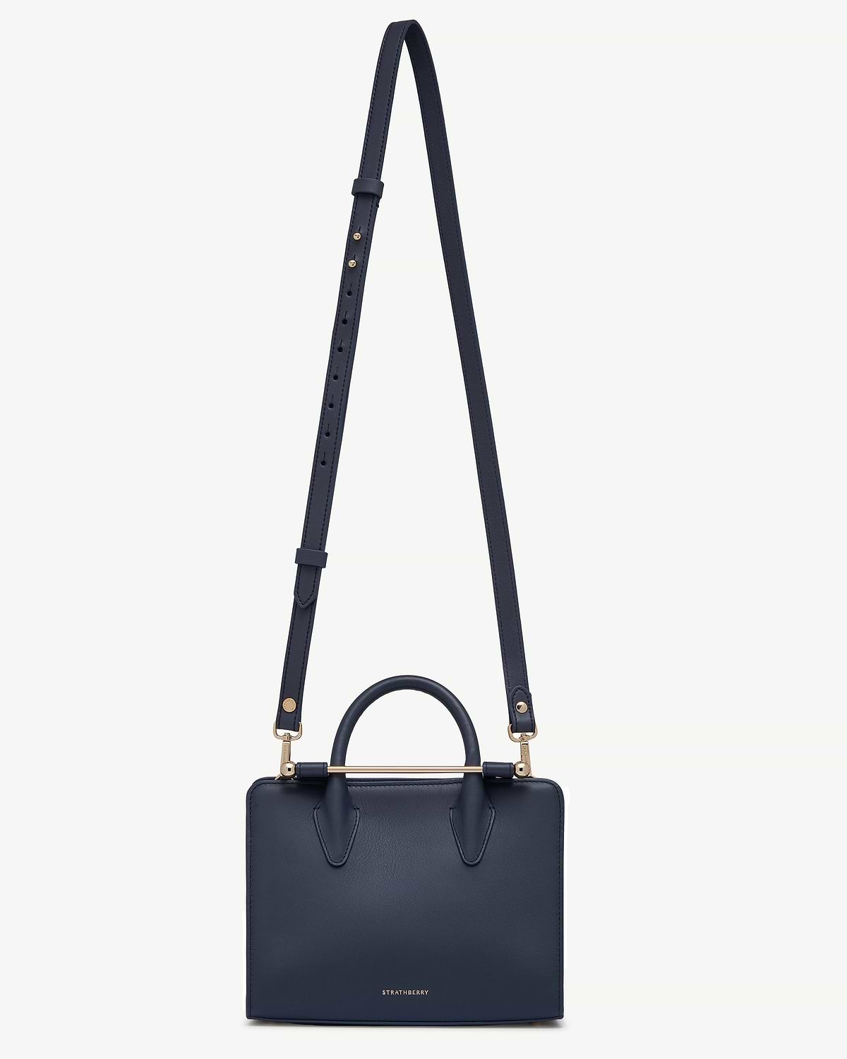 Marine blue thin adjustable leather strap attached to Strathberry bag with gold hardware