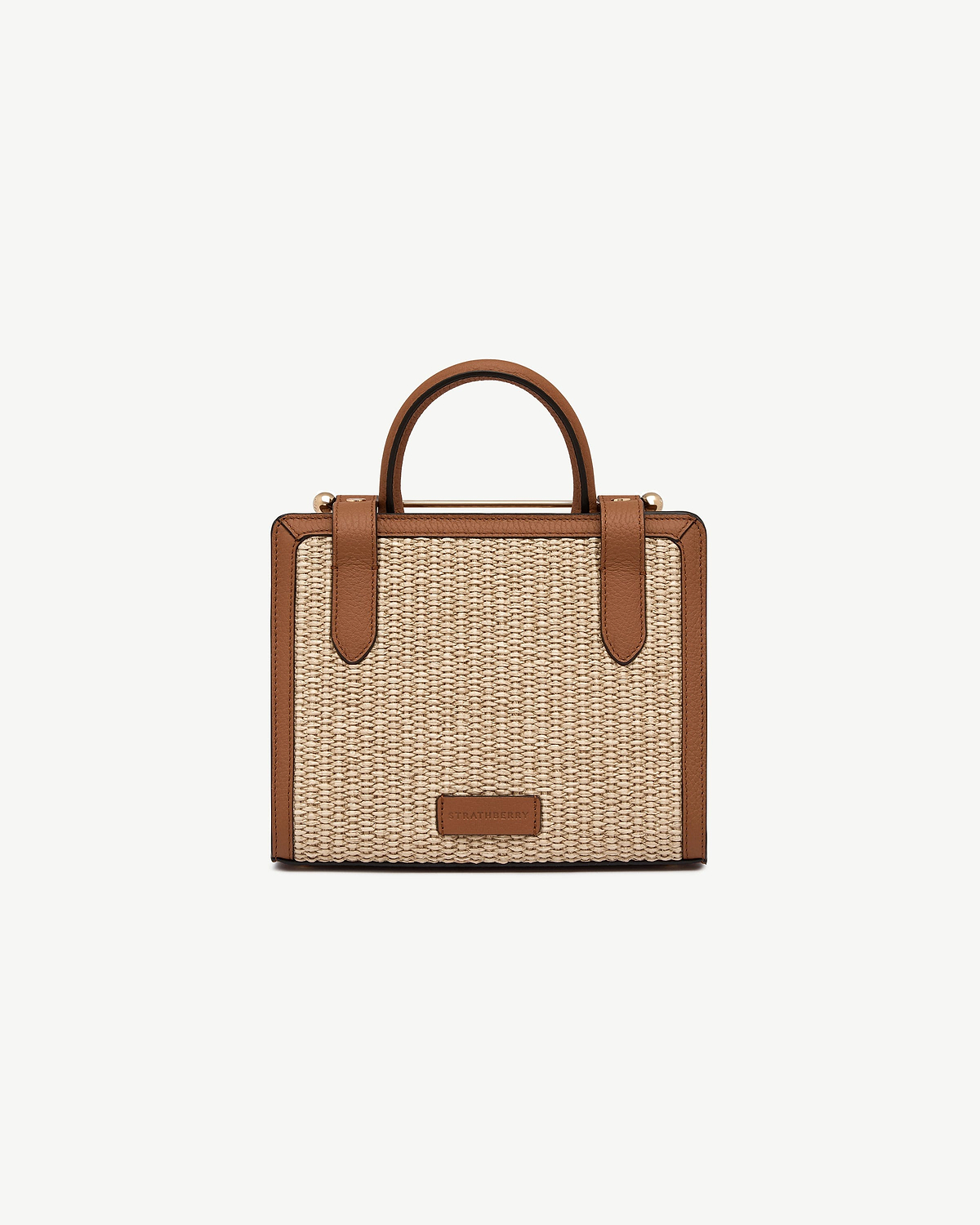 Mini tote in tan leather trim with natural raffia body and Strathberry logo.