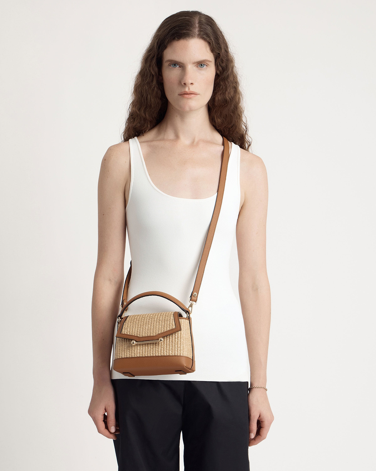 Model wearing tan and natural raffia Mosaic Nano crossbody bag with leather trim