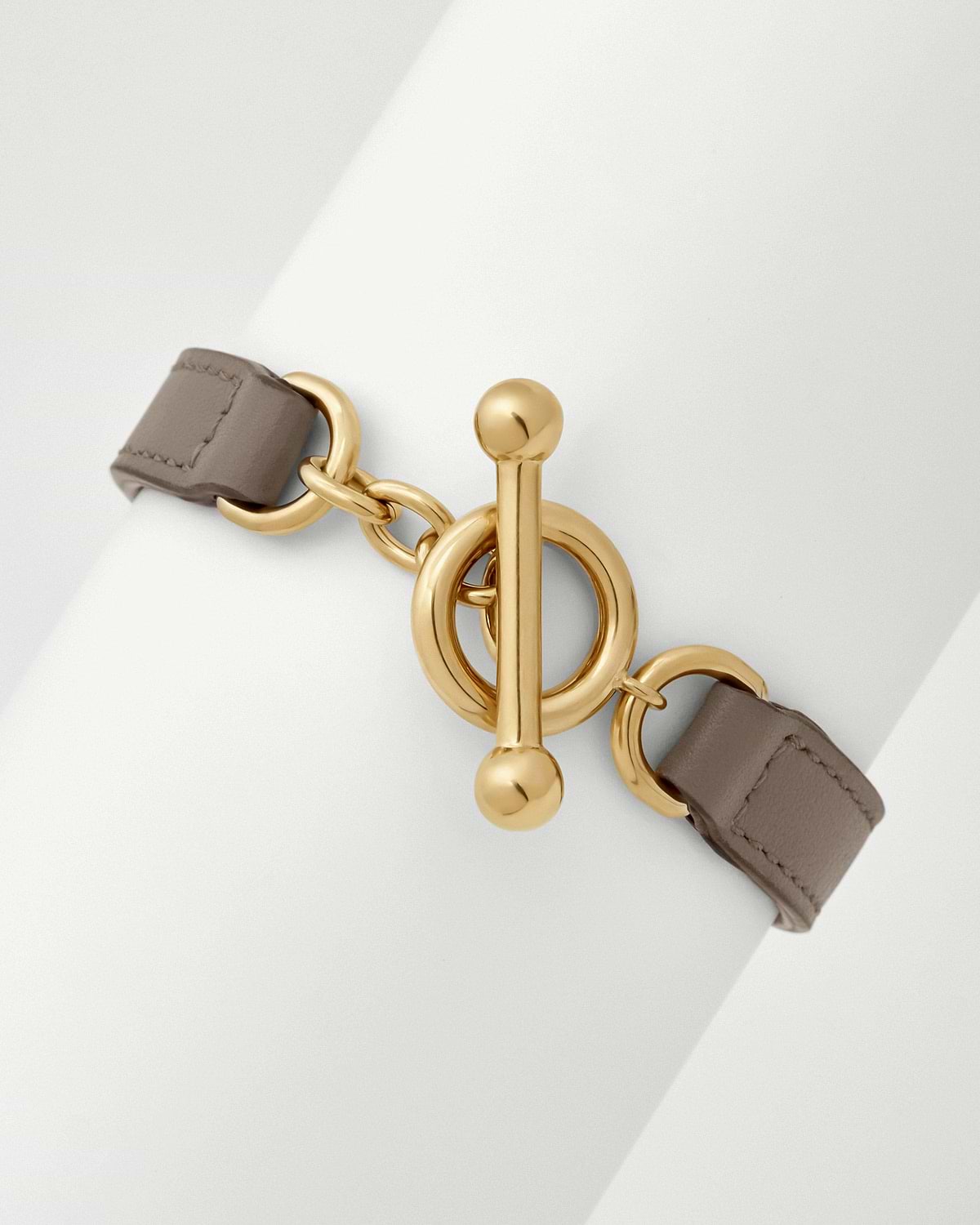 Taupe leather kite bracelet showing gold toggle fastening and linked rings