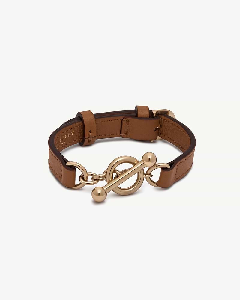Tan leather bracelet with gold circular toggle clasp and adjustable buckle